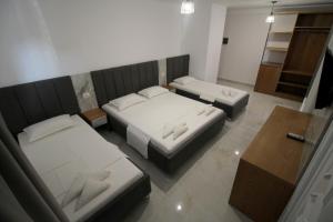 a room with two beds and a table at Hotel Four Islands in Ksamil