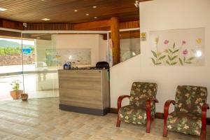 a waiting room with two chairs and a counter at Pousada Pescador in Ubatuba