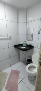 a bathroom with a toilet and a sink and a mirror at Promessa divina Carneiros in Tamandaré