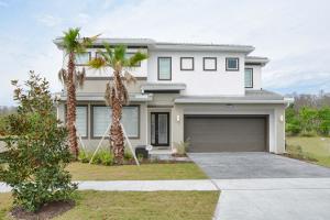 a white house with palm trees in front of it at Sonoma - 6 Bedroom Pool Home- 1856SN in Kissimmee