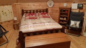 een slaapkamer met een bed en een stoel in een kamer bij Chalet Finlandais et Sauna 2 pers in Gosnay