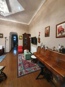 a living room with a piano and a red chair at Guest house tm in Tbilisi City