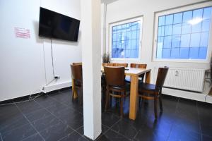 una sala da pranzo con tavolo, sedie e TV a schermo piatto di City Apartment am Hildeboldplatz a Colonia