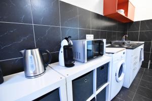 a kitchen with a counter with a microwave and a appliance at City Apartment am Hildeboldplatz in Cologne
