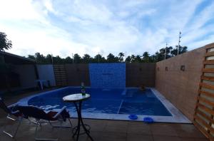una piccola piscina con tavolo e sedie in un cortile sul retro di Hibiscus Casa Condomínio com Piscina a Maceió