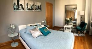 1 dormitorio con 1 cama con sábanas y almohadas azules en APARTAMENTO ANOVA, en Padrón