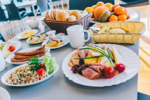 a table with plates of food and baskets of fruit at Sanatorium Rosomak in Ustroń