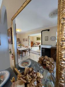 a mirror reflecting a living room with a dining room at La Fenice in Montefiascone