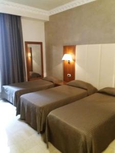 ローマにあるフェデリカズ スイート ホームのベッド2台と鏡が備わるホテルルームです。