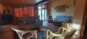 sala de estar con sofá y sillas en Casa Féliz duplex y apartamento Rural, en Torres del Obispo