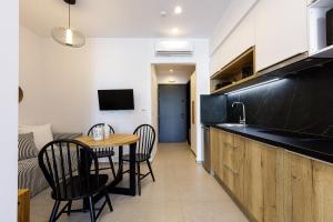 a kitchen with a table and chairs and a kitchen with a sink at Eleven Boutique Suites in Stavromenos