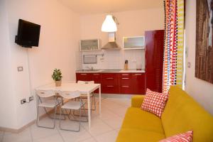 a living room with a couch and a table and a kitchen at Jonico Guest House in Scanzano