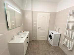 łazienka z umywalką i pralką w obiekcie Apartments Magnolia w Mariańskich Łaźniach +16 zdjęć