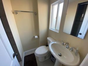 een badkamer met een wastafel, een toilet en een spiegel bij Casa Tranquila in Santa Ana