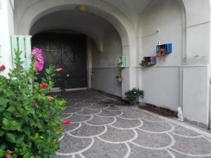 un couloir d'un immeuble avec une porte et des fleurs dans l'établissement Il Giardino degli Agrumi, à Caserte