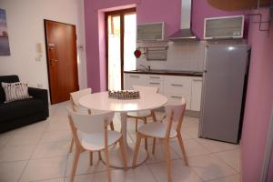 a kitchen with a table and chairs and a refrigerator at Jonico Guest House in Scanzano