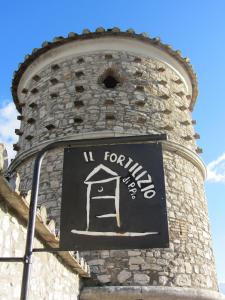 a sign on the side of a brick tower at Il Fortilizio in Pietrelcina