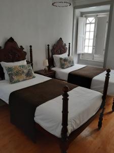 a bedroom with two beds and a window at Hotel Ribamar in Nazaré