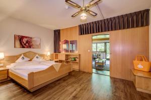 a bedroom with a bed and a ceiling fan at Alpenhof Lodge in Saltusio +28 photos