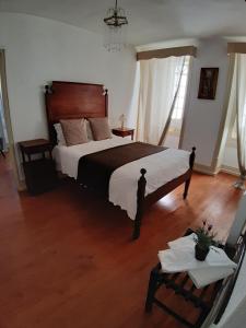 a bedroom with a large bed and a wooden floor at Hotel Ribamar in Nazaré