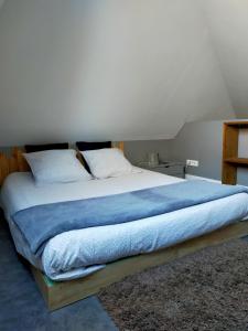 a bedroom with a large bed with a blue blanket at spéculoos et chicorée in Villeneuve d'Ascq