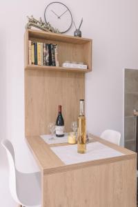 a table with a bottle of wine and two glasses at VS Studio Apartmani Banja Koviljača in Banja Koviljača +3 photos