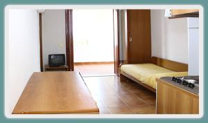 ジョイオーザ・マレーアにあるVRclub - Villa Ridente Residenceのキッチン(ベッド1台、テレビ付)が備わる客室です。