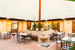 Argonauti Greenblu Resort في مارينا دي بيستيتشي: فناء به طاولات وكراسي في مبنى