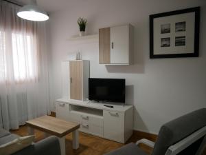 ein Wohnzimmer mit einem TV und einem weißen Schrank in der Unterkunft Principat-Vacances Pirinenca in Incles