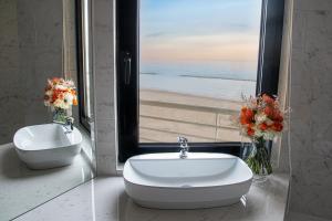 a bathroom with a sink and a view of the beach at AmbientHotels Panoramic in Rimini