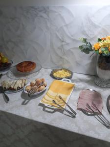 a table topped with plates of food and utensils at Hotel Veneza in Rio do Sul