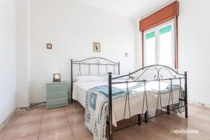 sypialnia z łóżkiem i oknem w obiekcie Bilocale Lungomare a Gallipoli w mieście Gallipoli