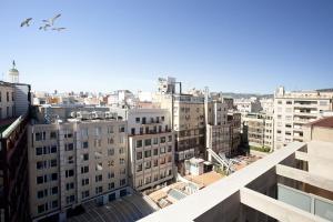 バルセロナにあるレッツゴー パセオ デ グラシアの建物のある都を飛ぶ鳥