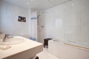 a white bathroom with a sink and a bath tub at LetsGo Paseo de Gracia in Barcelona