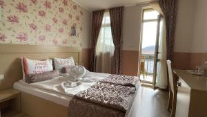 a small room with a bed with a window and a window at Hotel Anhea in Veliko Tŭrnovo