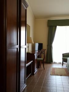 a hotel room with a desk and a television at Hotel Villa Peretti in Gela