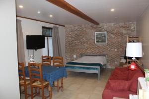 1 dormitorio con 1 cama, mesa y sillas en Saffels Nest 33, en Lochristi
