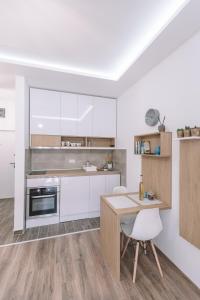 a kitchen with white cabinets and a wooden table at VS Studio Apartmani Banja Koviljača in Banja Koviljača