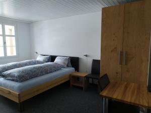 - une chambre avec un lit et une armoire en bois dans l'établissement Café-Conditorei Hotel Huber, à Lichtensteig