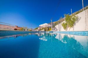 a swimming pool with blue water and a blue sky at Apartments Emil in Lokva Rogoznica
