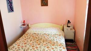 a small bedroom with a bed with a floral bedspread at Holiday Home Olib in Olib