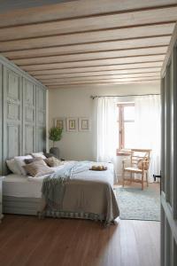 1 dormitorio con 1 cama grande y techo de madera en Herba-ház, en Dánszentmiklós