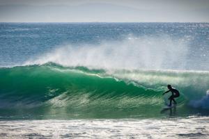 a man riding a wave on a surfboard in the ocean at Flamebreeze Corner @ Supertubes Jeffreys Bay in Jeffreys Bay