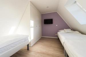 Zimmer im Dachgeschoss mit 2 Betten und einem TV in der Unterkunft Meeresrauschen - Landhaus Tadsen in Westerland