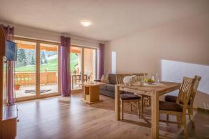 a living room with a wooden table and a dining room at Oberfasser in Westendorf