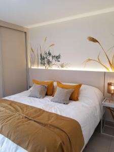 a bedroom with a large white bed with pillows at Terra Departamentos Boutique in La Falda