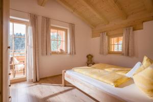 a bedroom with a bed and two windows at Oberfasser in Westendorf