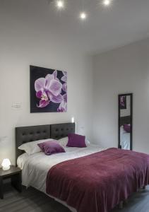 a bedroom with a large bed with purple pillows at Le Stanze dei Fiori in Bologna