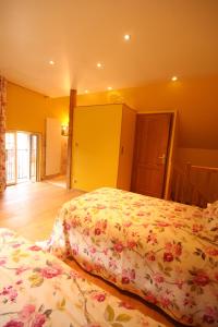 two beds in a room with yellow walls at Auberge Les Tilleuls in Vincelottes