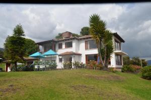 een huis op een heuvel met een groene tuin bij Hacienda San Pedro Claver Subachoque in Subachoque
